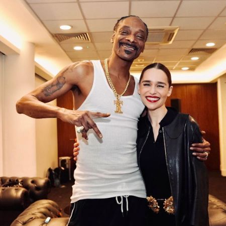 Emilia Clarke is wearing a black dress and Snoop Dogg is wearing a white vest and trouser.